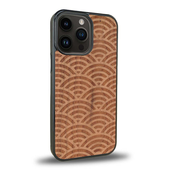 Coque de protection en bois véritable fabriquée en France pour iPhone 15 Pro baptisée "La Sinjak" avec un motif de gravure abstrait représentant la répétition d'un symbole wifi