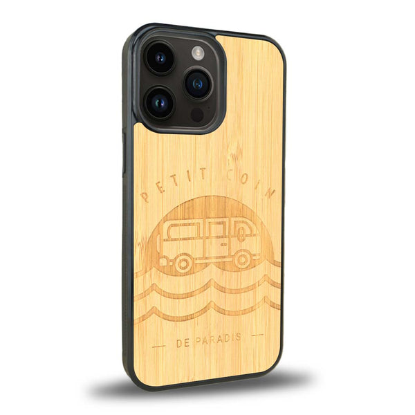 Coque de protection en bois véritable fabriquée en France pour iPhone 15 Pro sur le thème des voyages en vans, vanlife et chill avec une gravure représentant un van vw combi devant le soleil couchant sur une plage avec des vagues