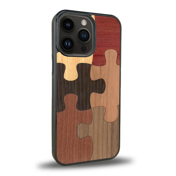 Coque de protection en bois véritable fabriquée en France pour iPhone 15 Pro représentant un puzzle en six pièces qui allie du chêne fumé, du noyer, du bambou, du padouk, du merisier et de l'acajou