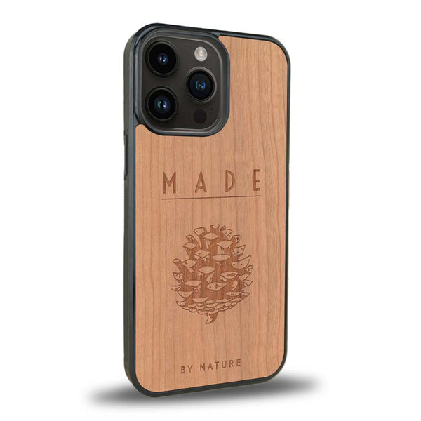 Coque de protection en bois véritable fabriquée en France pour iPhone 15 Pro sur le thème de la nature et des arbres avec une gravure représentant une pomme de pin et la phrase "made by nature"