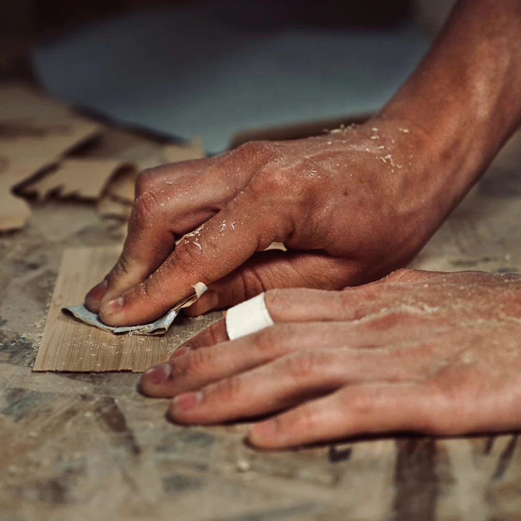 Les mains d'un artisan qui travaille du bois.