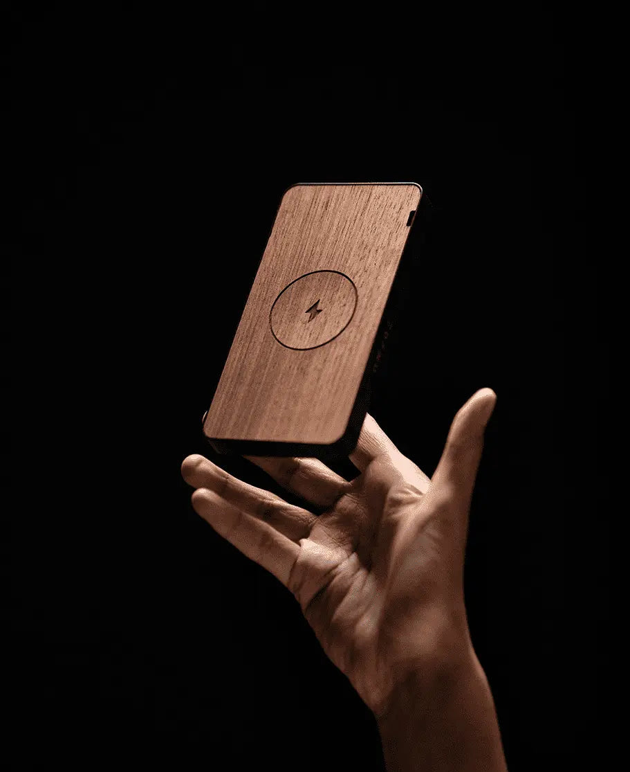 Une main avec une batterie externe portable en bois pour téléphone, capacité 10 000 mAh.