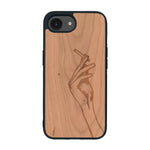 Coque de protection en bois véritable fabriquée en France pour iPhone 16e représentant une main de femme tenant une cigarette de type line art en collaboration avec l'artiste Maud Dabs