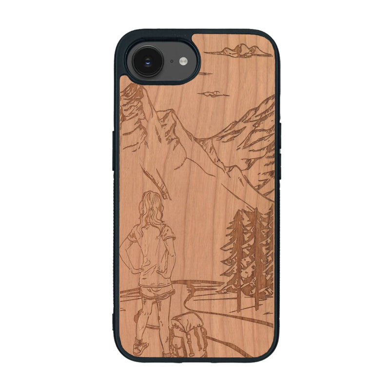 Coque de protection en bois véritable fabriquée en France pour iPhone 16e sur le thème de la randonnée en montagne et de l'aventure avec une gravure représentant une femme de dos face à un paysage de nature