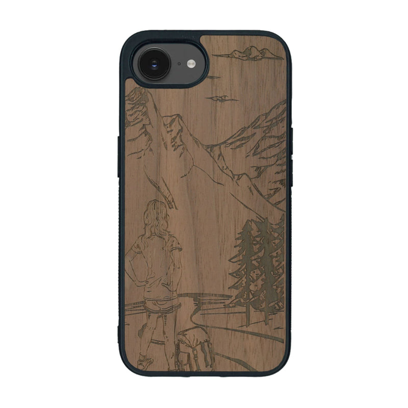 Coque de protection en bois véritable fabriquée en France pour iPhone 16e sur le thème de la randonnée en montagne et de l'aventure avec une gravure représentant une femme de dos face à un paysage de nature