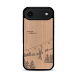 Coque de protection en bois véritable fabriquée en France pour  sur le thème de la montagne, du ski et de la neige avec un motif représentant une paire de ski plantée dans la neige avec en fond des montagnes enneigées