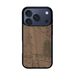 Coque de protection en bois véritable fabriquée en France pour iPhone 17 Pro sur le thème de la randonnée en montagne et de l'aventure avec une gravure représentant une femme de dos face à un paysage de nature