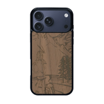 Coque de protection en bois véritable fabriquée en France pour iPhone 17 Pro Max sur le thème de la randonnée en montagne et de l'aventure avec une gravure représentant une femme de dos face à un paysage de nature