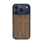 Coque de protection en bois véritable fabriquée en France pour iPhone 17 Pro sur le thème de la montagne, du ski et de la neige avec un motif représentant une paire de ski plantée dans la neige avec en fond des montagnes enneigées