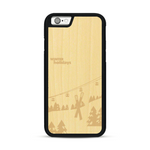 Coque de protection en bois véritable fabriquée en France pour  sur le thème de la montagne, du ski et de la neige avec un motif représentant une paire de ski plantée dans la neige avec en fond des montagnes enneigées