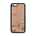 Coque de protection en bois véritable fabriquée en France pour  sur le thème de la montagne, du ski et de la neige avec un motif représentant une paire de ski plantée dans la neige avec en fond des montagnes enneigées