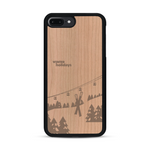 Coque de protection en bois véritable fabriquée en France pour  sur le thème de la montagne, du ski et de la neige avec un motif représentant une paire de ski plantée dans la neige avec en fond des montagnes enneigées