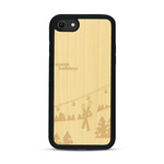 Coque de protection en bois véritable fabriquée en France pour  sur le thème de la montagne, du ski et de la neige avec un motif représentant une paire de ski plantée dans la neige avec en fond des montagnes enneigées