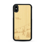 Coque de protection en bois véritable fabriquée en France pour  sur le thème de la montagne, du ski et de la neige avec un motif représentant une paire de ski plantée dans la neige avec en fond des montagnes enneigées