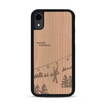 Coque de protection en bois véritable fabriquée en France pour  sur le thème de la montagne, du ski et de la neige avec un motif représentant une paire de ski plantée dans la neige avec en fond des montagnes enneigées