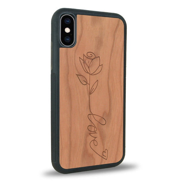 Coque de protection en bois véritable fabriquée en France pour iPhone XS sur le thème de la fête des mères avec un motif représentant une fleur dont la tige forme le mot "love"