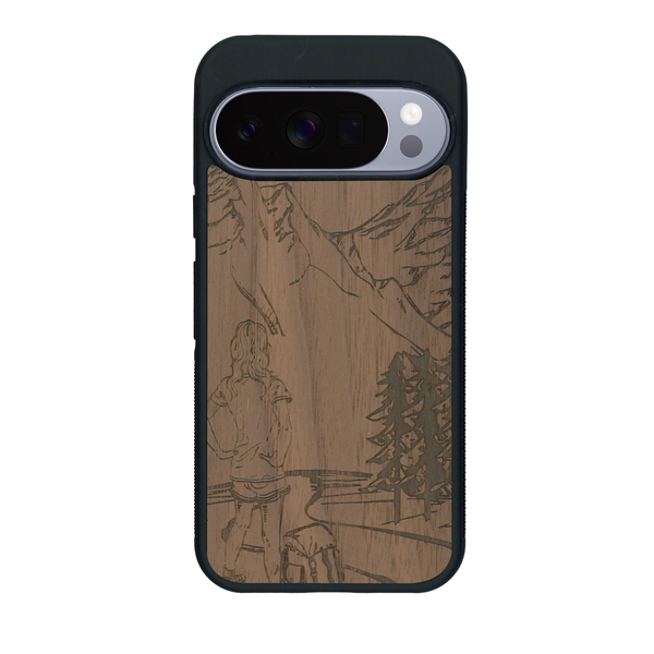 Coque de protection en bois véritable fabriquée en France pour Google Pixel 10 sur le thème de la randonnée en montagne et de l'aventure avec une gravure représentant une femme de dos face à un paysage de nature