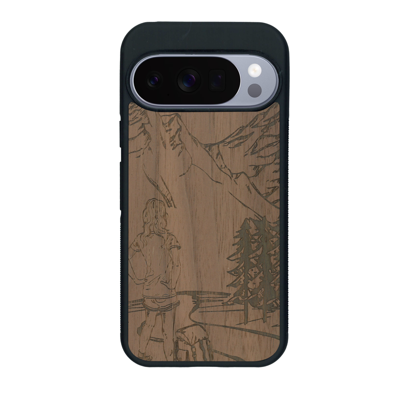 Coque de protection en bois véritable fabriquée en France pour Google Pixel 10 sur le thème de la randonnée en montagne et de l'aventure avec une gravure représentant une femme de dos face à un paysage de nature