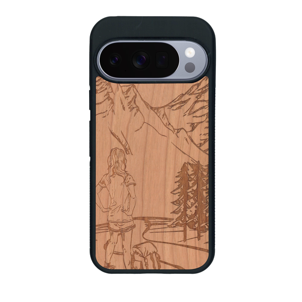 Coque de protection en bois véritable fabriquée en France pour Google Pixel 10 Pro sur le thème de la randonnée en montagne et de l'aventure avec une gravure représentant une femme de dos face à un paysage de nature