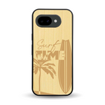 Coque de protection en bois véritable fabriquée en France pour Google Pixel 10A sur le thème chill avec un motif représentant une silouhette tenant une planche de surf sur une plage entouré de palmiers et les mots "Surf Time Long Beach Miami"