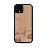 Coque de protection en bois véritable fabriquée en France pour  sur le thème de la montagne, du ski et de la neige avec un motif représentant une paire de ski plantée dans la neige avec en fond des montagnes enneigées