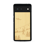 Coque de protection en bois véritable fabriquée en France pour  sur le thème de la montagne, du ski et de la neige avec un motif représentant une paire de ski plantée dans la neige avec en fond des montagnes enneigées