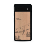 Coque de protection en bois véritable fabriquée en France pour  sur le thème de la montagne, du ski et de la neige avec un motif représentant une paire de ski plantée dans la neige avec en fond des montagnes enneigées