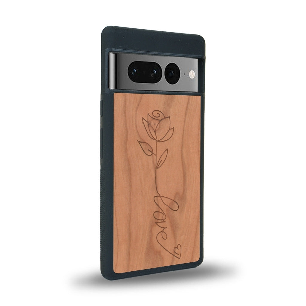 Coque de protection en bois véritable fabriquée en France pour Google Pixel 7 sur le thème de la fête des mères avec un motif représentant une fleur dont la tige forme le mot "love"