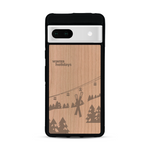 Coque de protection en bois véritable fabriquée en France pour  sur le thème de la montagne, du ski et de la neige avec un motif représentant une paire de ski plantée dans la neige avec en fond des montagnes enneigées