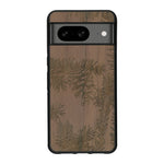 Coque de protection en bois véritable fabriquée en France pour Google Pixel 7A sur le thème de la nature des arbres avec un motif de gravure représentant des épines de sapin et des pommes de pin