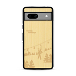 Coque de protection en bois véritable fabriquée en France pour  sur le thème de la montagne, du ski et de la neige avec un motif représentant une paire de ski plantée dans la neige avec en fond des montagnes enneigées