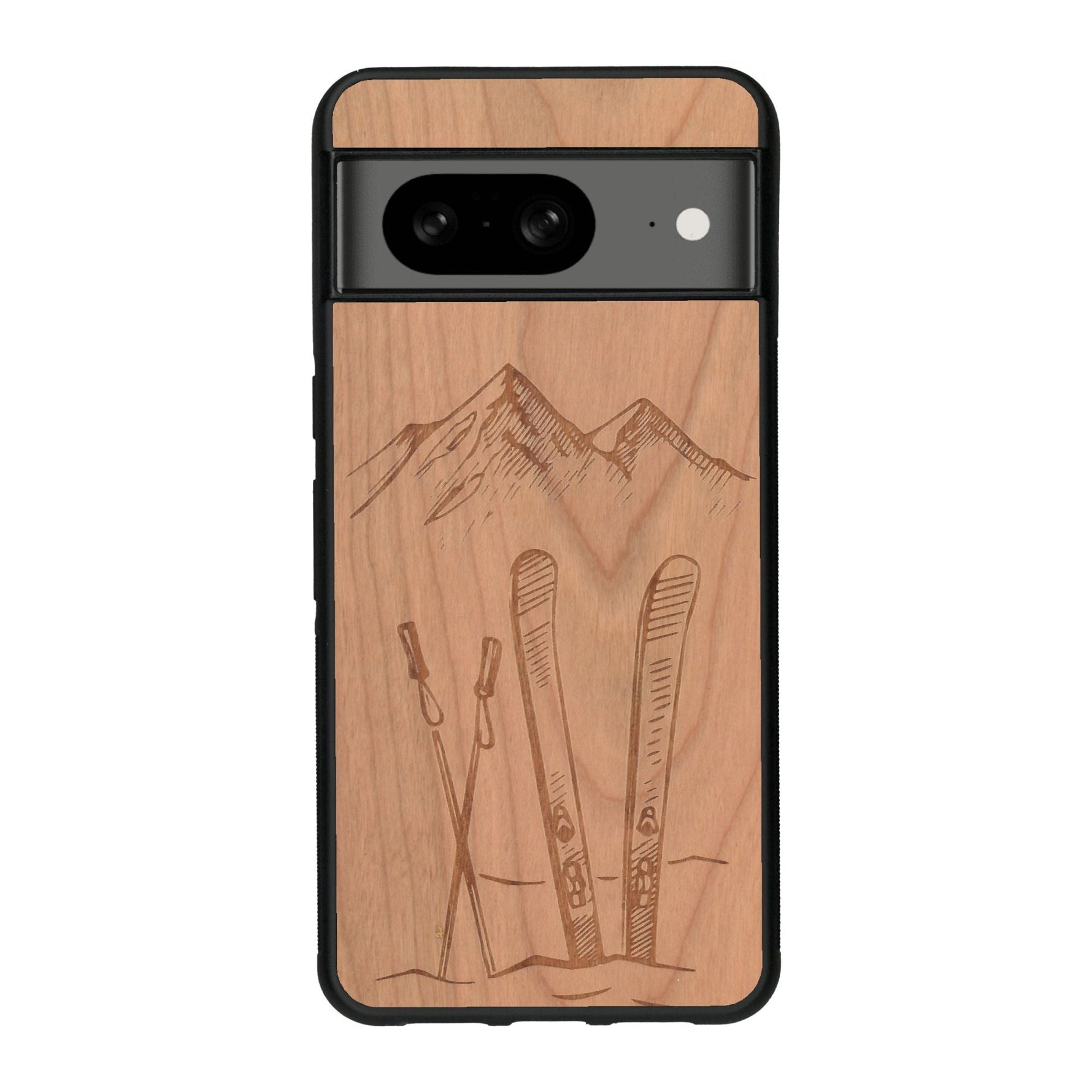 Coque de protection en bois véritable fabriquée en France pour Google Pixel 7A sur le thème de la montagne, du ski et de la neige avec un motif représentant une paire de ski plantée dans la neige avec en fond des montagnes enneigées