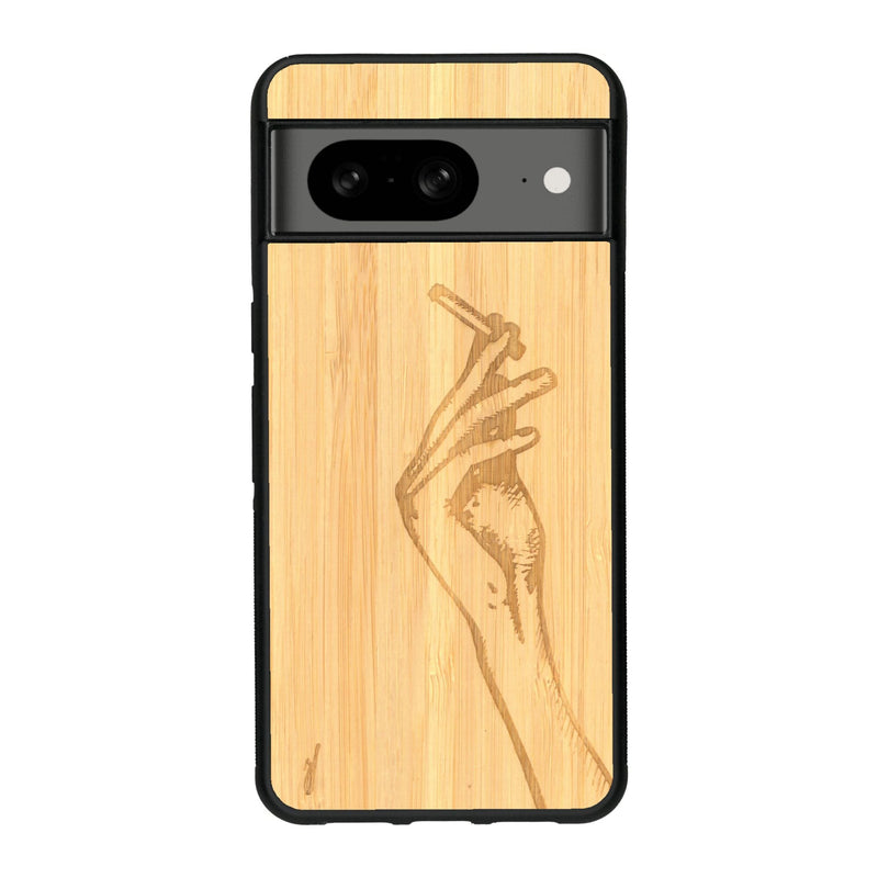 Coque de protection en bois véritable fabriquée en France pour Google Pixel 8 représentant une main de femme tenant une cigarette de type line art en collaboration avec l'artiste Maud Dabs