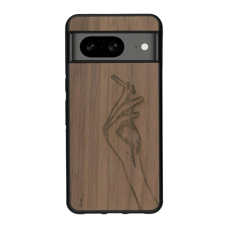 Coque de protection en bois véritable fabriquée en France pour Google Pixel 8 représentant une main de femme tenant une cigarette de type line art en collaboration avec l'artiste Maud Dabs