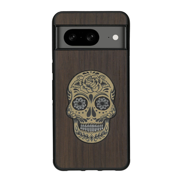 Coque de protection en bois véritable fabriquée en France pour Google Pixel 8 alliant du chêne fumé avec du métal argenté et doré représentant une tête de mort mexicaine sur le thème Dia de los Muertos