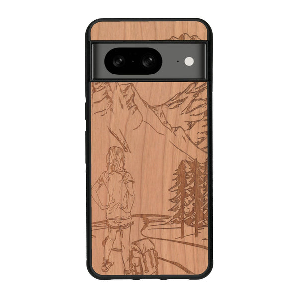 Coque de protection en bois véritable fabriquée en France pour Google Pixel 8 sur le thème de la randonnée en montagne et de l'aventure avec une gravure représentant une femme de dos face à un paysage de nature