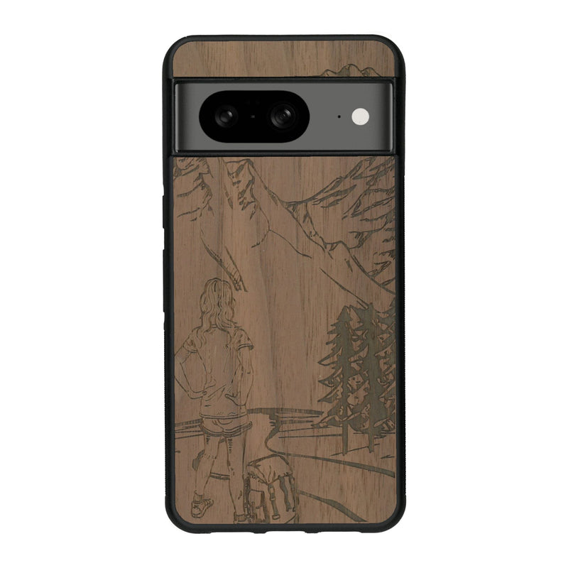 Coque de protection en bois véritable fabriquée en France pour Google Pixel 8 sur le thème de la randonnée en montagne et de l'aventure avec une gravure représentant une femme de dos face à un paysage de nature