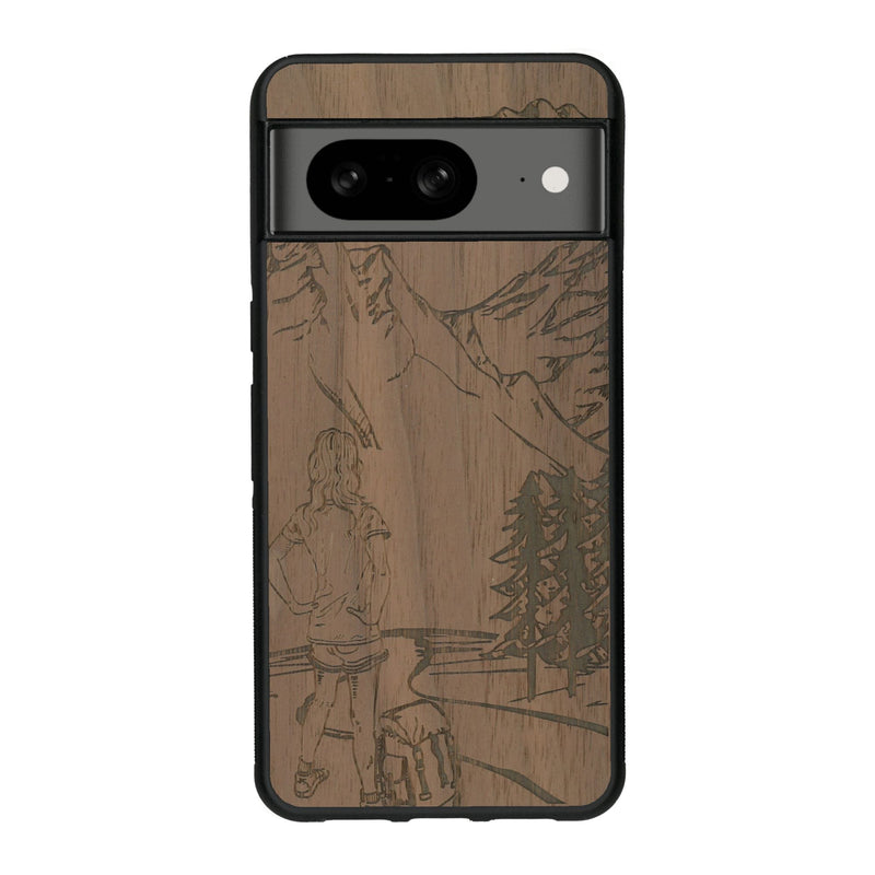 Coque de protection en bois véritable fabriquée en France pour Google Pixel 8 sur le thème de la randonnée en montagne et de l'aventure avec une gravure représentant une femme de dos face à un paysage de nature