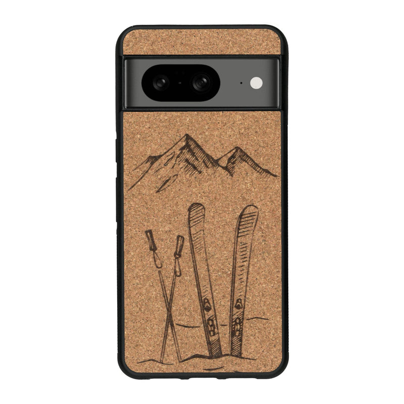 Coque de protection en bois véritable fabriquée en France pour Google Pixel 8 sur le thème de la montagne, du ski et de la neige avec un motif représentant une paire de ski plantée dans la neige avec en fond des montagnes enneigées