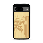 Coque de protection en bois véritable fabriquée en France pour  sur le thème chill avec un motif représentant une silouhette tenant une planche de surf sur une plage entouré de palmiers et les mots "Surf Time Long Beach Miami"