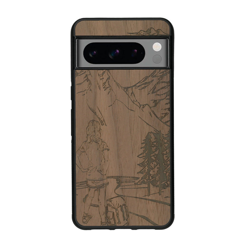 Coque de protection en bois véritable fabriquée en France pour Google Pixel 8pro sur le thème de la randonnée en montagne et de l'aventure avec une gravure représentant une femme de dos face à un paysage de nature