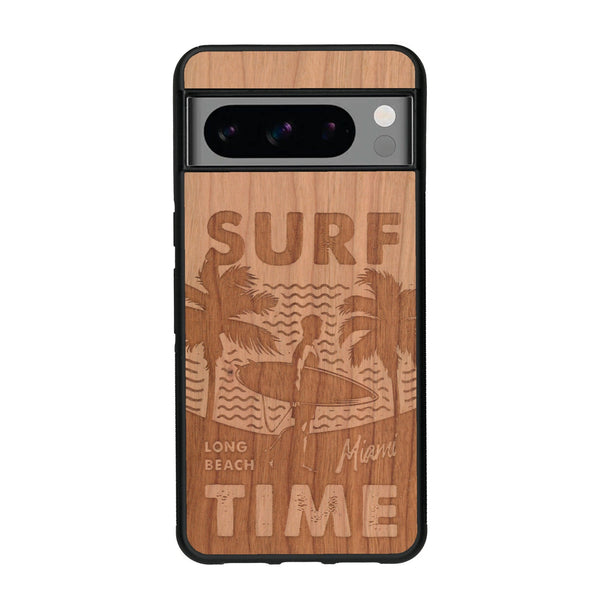 Coque de protection en bois véritable fabriquée en France pour Google Pixel 8pro sur le thème chill avec un motif représentant une silouhette tenant une planche de surf sur une plage entouré de palmiers et les mots "Surf Time Long Beach Miami"