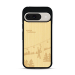 Coque de protection en bois véritable fabriquée en France pour  sur le thème de la montagne, du ski et de la neige avec un motif représentant une paire de ski plantée dans la neige avec en fond des montagnes enneigées