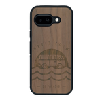 Coque de protection en bois véritable fabriquée en France pour Google Pixel 9A sur le thème des voyages en vans, vanlife et chill avec une gravure représentant un van vw combi devant le soleil couchant sur une plage avec des vagues