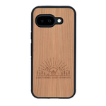 Coque de protection en bois véritable fabriquée en France pour Google Pixel 9A sur le thème chill et nature avec un motif représentant un levé de soleil sur un paysage de montagne avec des sapins et un chalet et la phrase "Good friends, good adventure"