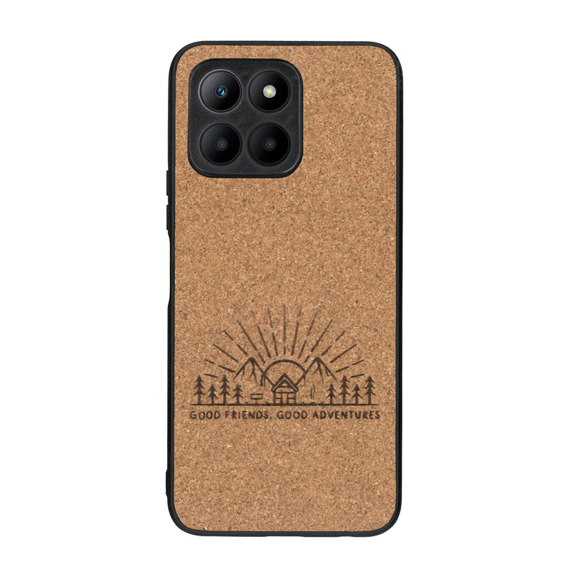 Coque de protection en bois véritable fabriquée en France pour Honor 70 Lite sur le thème chill et nature avec un motif représentant un levé de soleil sur un paysage de montagne avec des sapins et un chalet et la phrase "Good friends, good adventure"