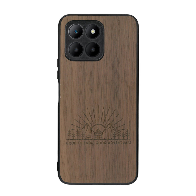 Coque de protection en bois véritable fabriquée en France pour Honor 70 Lite sur le thème chill et nature avec un motif représentant un levé de soleil sur un paysage de montagne avec des sapins et un chalet et la phrase "Good friends, good adventure"