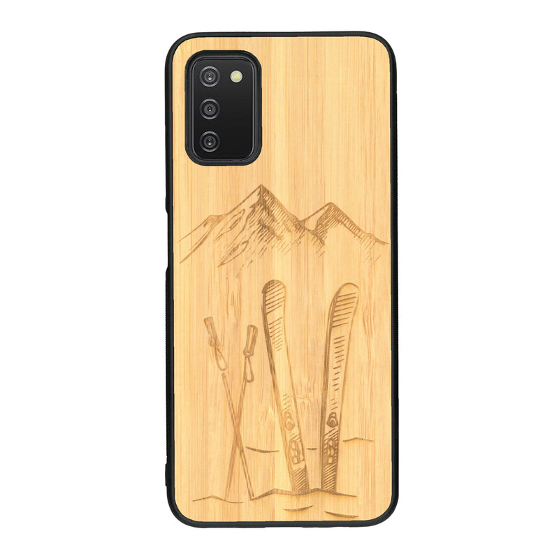 Coque de protection en bois véritable fabriquée en France pour Samsung A03S sur le thème de la montagne, du ski et de la neige avec un motif représentant une paire de ski plantée dans la neige avec en fond des montagnes enneigées