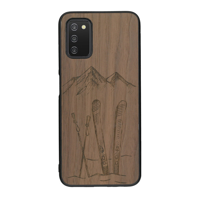 Coque de protection en bois véritable fabriquée en France pour Samsung A03S sur le thème de la montagne, du ski et de la neige avec un motif représentant une paire de ski plantée dans la neige avec en fond des montagnes enneigées
