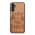 Coque de protection en bois véritable fabriquée en France pour Samsung A05S sur le thème chill avec un motif représentant une silouhette tenant une planche de surf sur une plage entouré de palmiers et les mots "Surf Time Long Beach Miami"